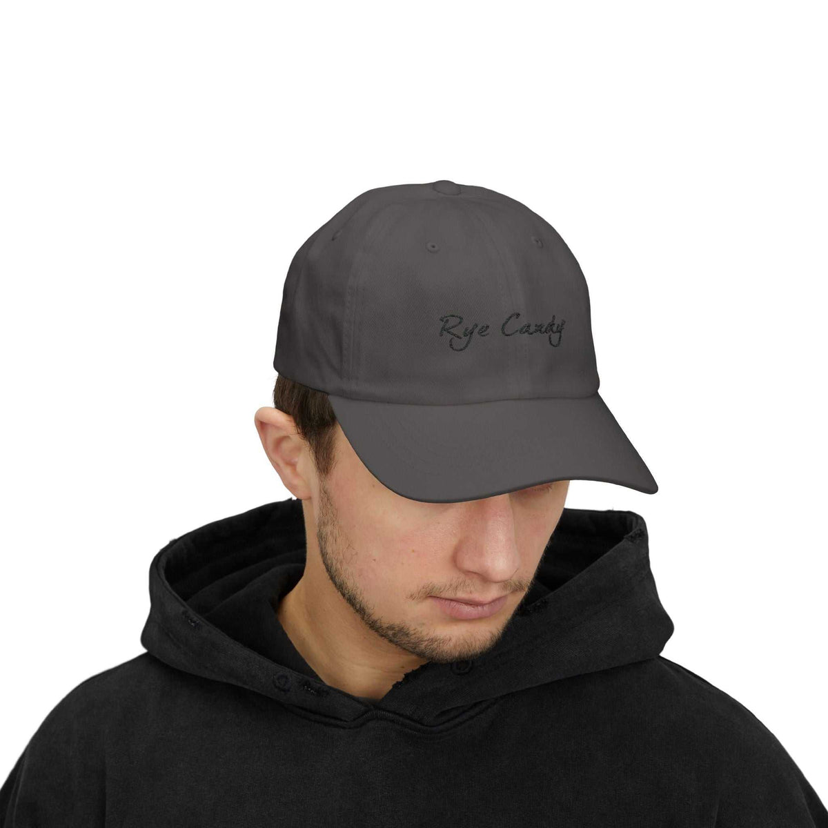 Man modeling dark gray 'Rye Candy' whiskey cap, a unisex fashion accessory perfect for casual and distillery-inspired looks.
