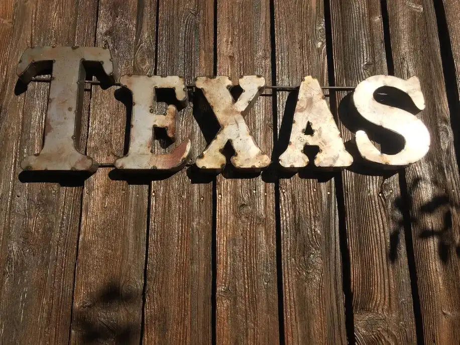 Rustic wall décor spelling TEXAS in recycled metal letters, perfect for home & garden accent décor with a vintage Western aesthetic.
