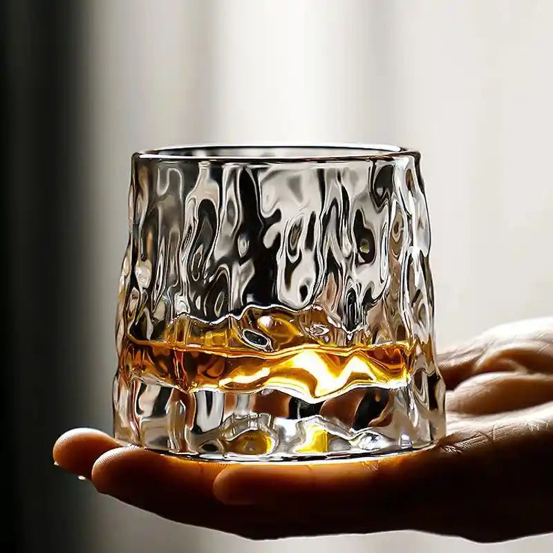 Molten-style Thick Rotating Whisky Glass resting on hand, designed for effortless swirling and enhanced whiskey aroma release.