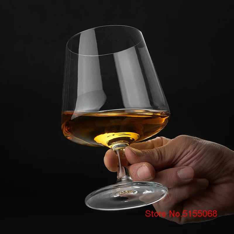 Hand presenting a filled Whiskey Snifter Glass from the elegant tasting set, emphasizing its crystal clarity and ideal shape for rye whiskey enjoyment.
