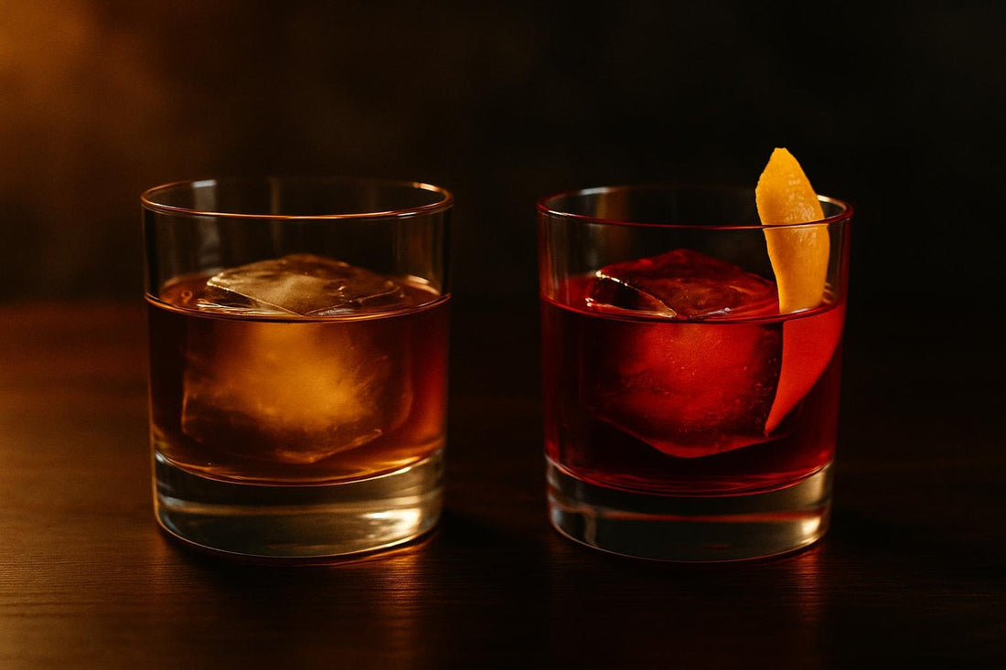 Amber Old Fashioned beside a ruby-red Negroni on dark walnut — Old Fashioned vs Negroni