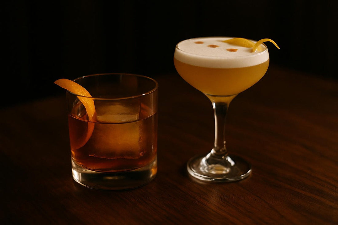 Old Fashioned beside a Whiskey Sour with egg-white foam — two whiskey classics compared