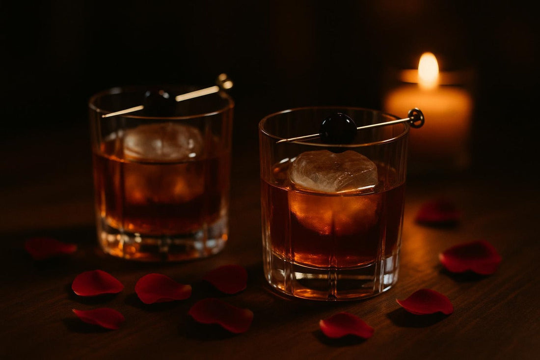 Two Old Fashioneds with brandied cherries beside rose petals and candlelight — Valentine's Old Fashioned
