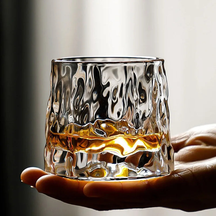 Luxurious whiskey tumbler with sculpted glass design and amber whiskey.