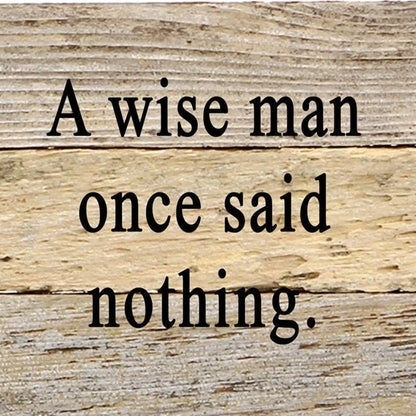 Reclaimed wood wall sign with black text 'A wise man once said nothing' on rustic light brown planks. Eco-friendly home décor accent.