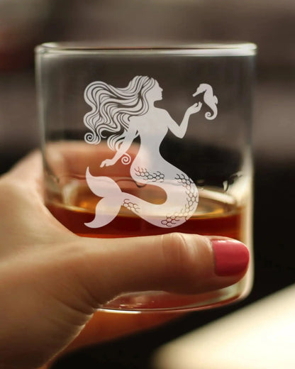 Hand holding Mermaid Whiskey Glass with etched mermaid and seahorse, highlighting its stylish design for beach lovers and cocktail fans.