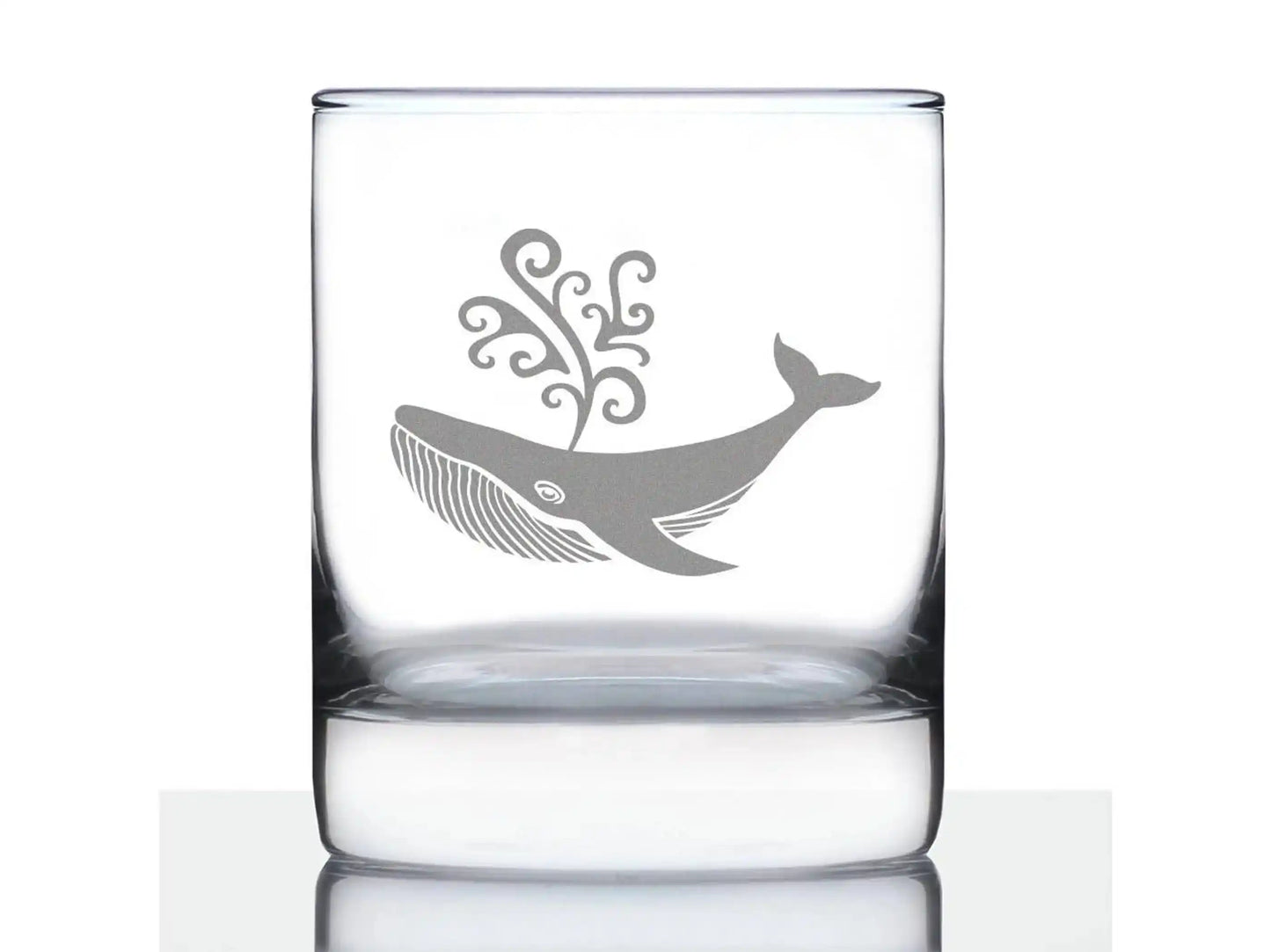 Clear glass tumbler with a whale design on a white background