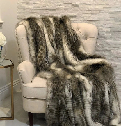 Alaskan Hawk Luxury Throw for Cozy Comfort draped over a cream armchair, adding warmth and luxury to home & garden interiors.