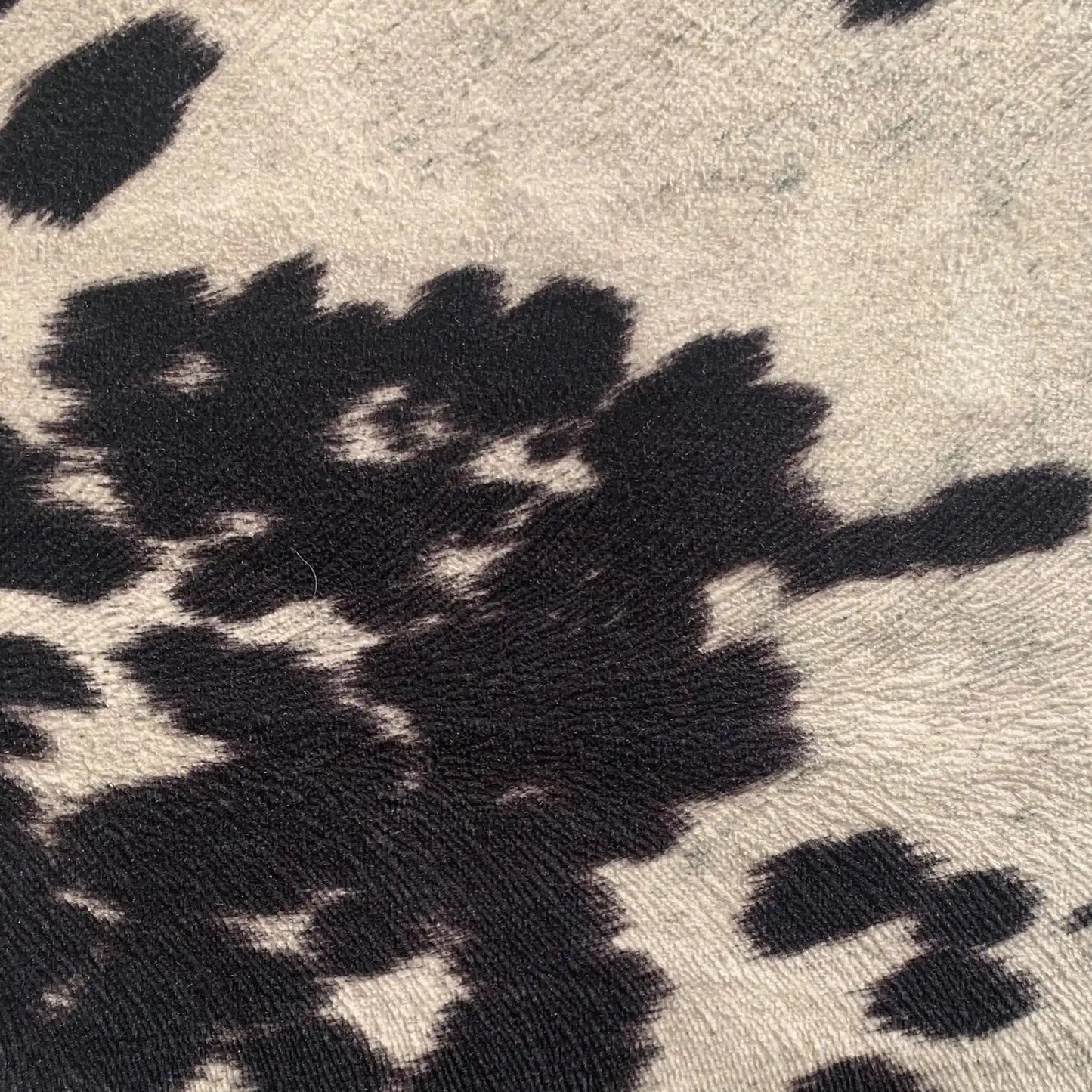 Rectangular luxury cowhide throw pillow with black and white pattern, designed for whiskey-themed rustic interiors.