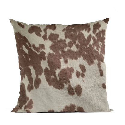 Premium cowhide throw pillow with brown and white spotted pattern, ideal for whiskey lovers seeking rustic home decor accents.
