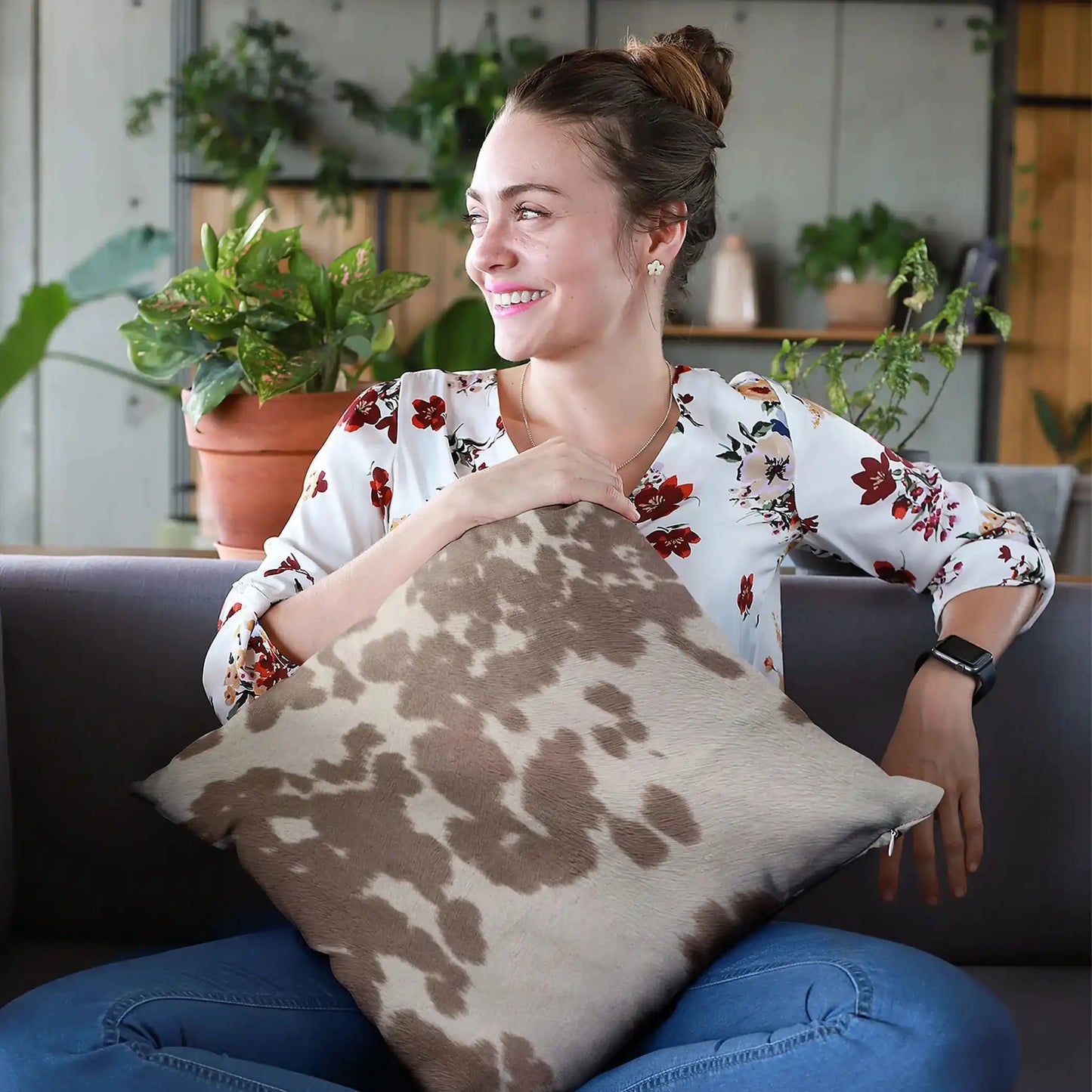 Set of premium cowhide throw pillows on a modern sofa, showcasing brown and white patterns for rustic whiskey lounge decor.