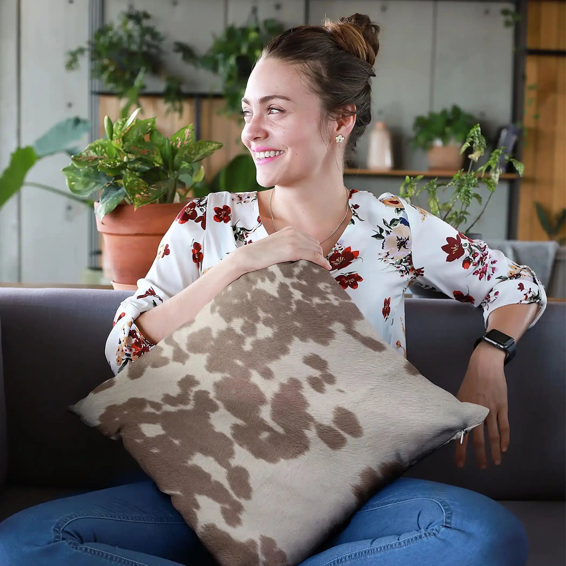 Set of premium cowhide throw pillows on a modern sofa, showcasing brown and white patterns for rustic whiskey lounge decor.
