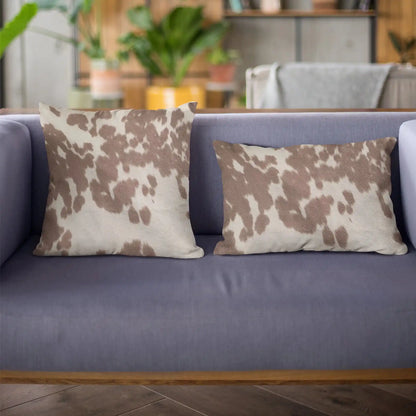 Close-up of premium cowhide throw pillow texture, highlighting natural brown and white pattern ideal for whiskey-inspired interiors.