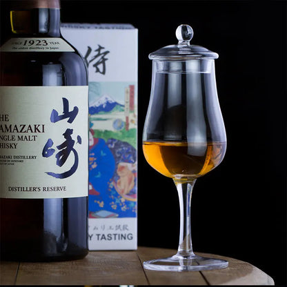 Whiskey glass with whiskey and bottle in background