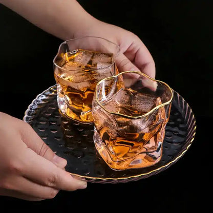 Two Japanese style twisted whiskey glasses with gold rim served on a tray, showcasing elegant design for scotch and cocktail drinks.