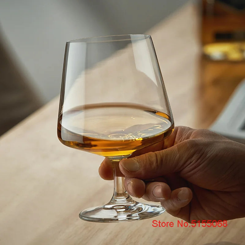 Hand holding whiskey glass with amber liquor