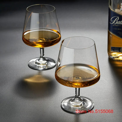 Whiskey glasses with bottles on dark table