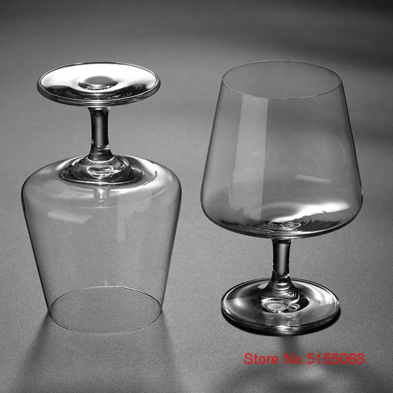Clear whiskey glasses with empty bases on gray background
