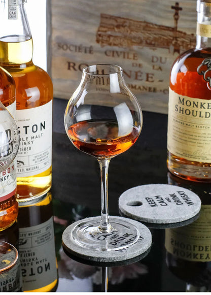 Whiskey tasting tulip glasses with whiskey bottles