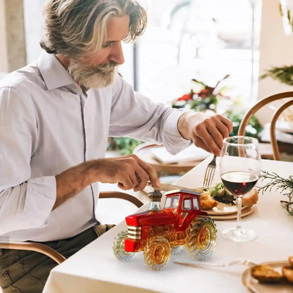 Red Glass Tractor Decanter on a dining table beside a wine glass, enhancing the meal with a touch of novelty and elegance.