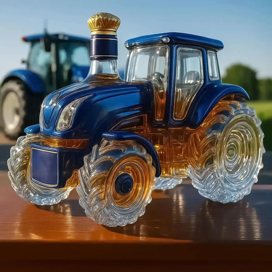 Elegant Glass Tractor Decanter in blue and amber tones, ideal for whiskey or wine, displayed outdoors with a real tractor in the background.