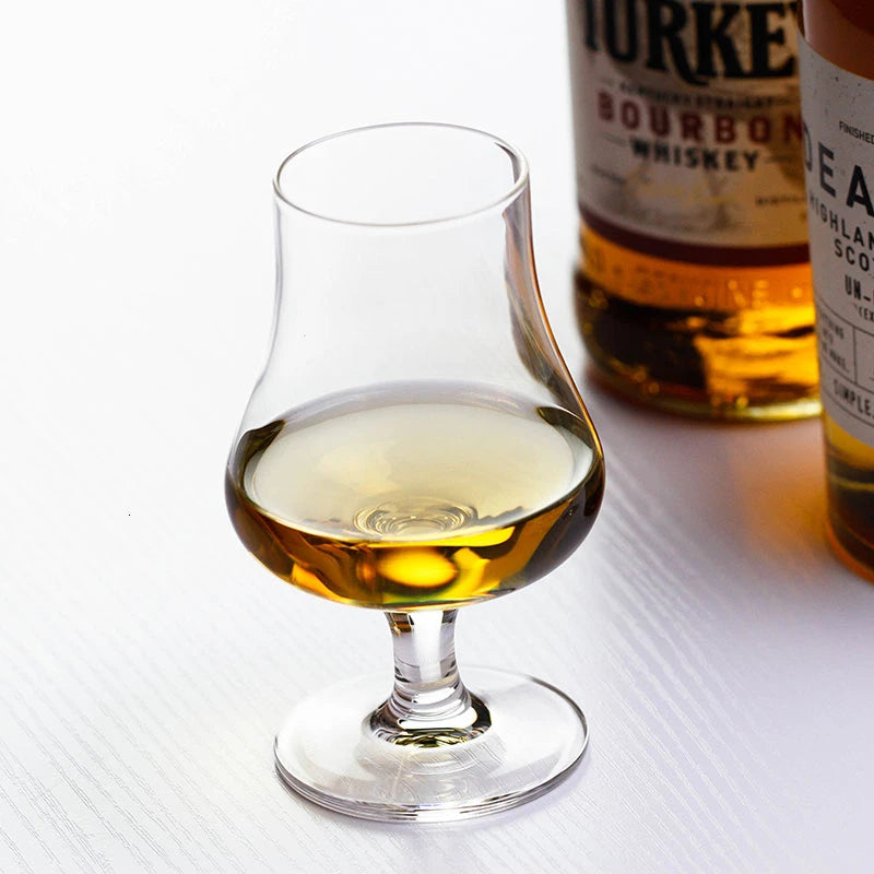 Elegant whisky glass with amber liquid on white background