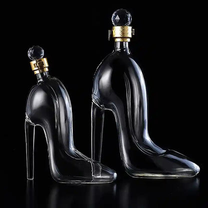 Set of two luxurious glass whiskey decanters shaped like high heel shoes with crystal stoppers, ideal for decorative and functional barware.