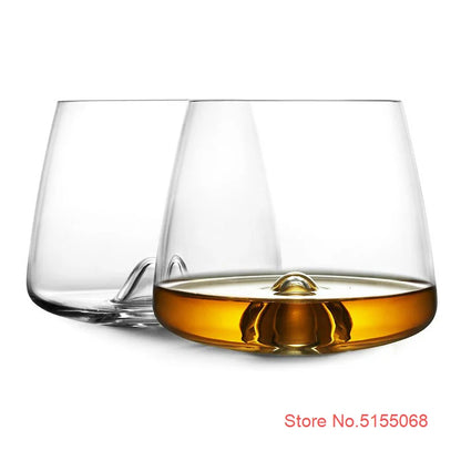 Clear whiskey glasses with whiskey on black surface