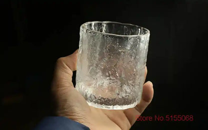 Hand holding frosted whiskey tumbler with Nordic Japanese crystal design, showcasing its textured surface and ergonomic size.