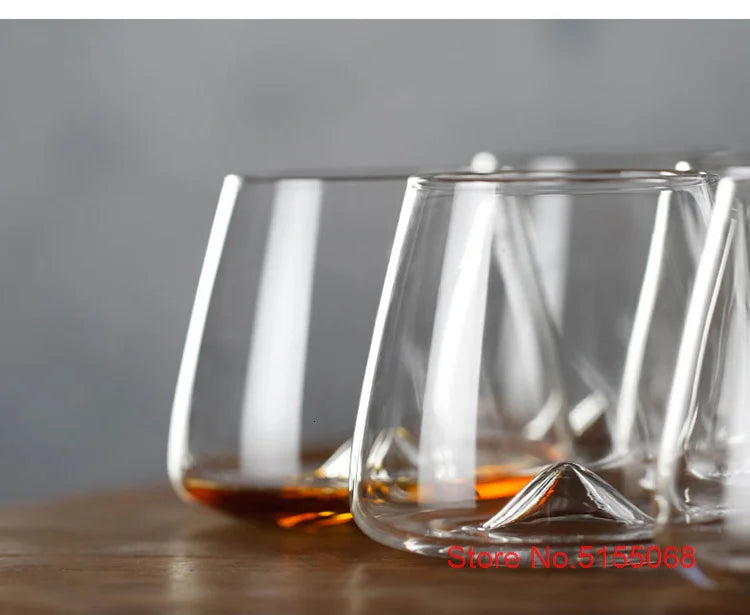 Elegant whiskey glasses with whiskey on wooden surface