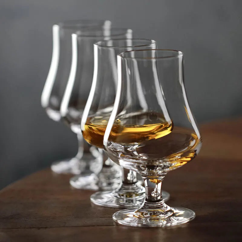 Set of four crystal whisky nosing glasses with amber liquid