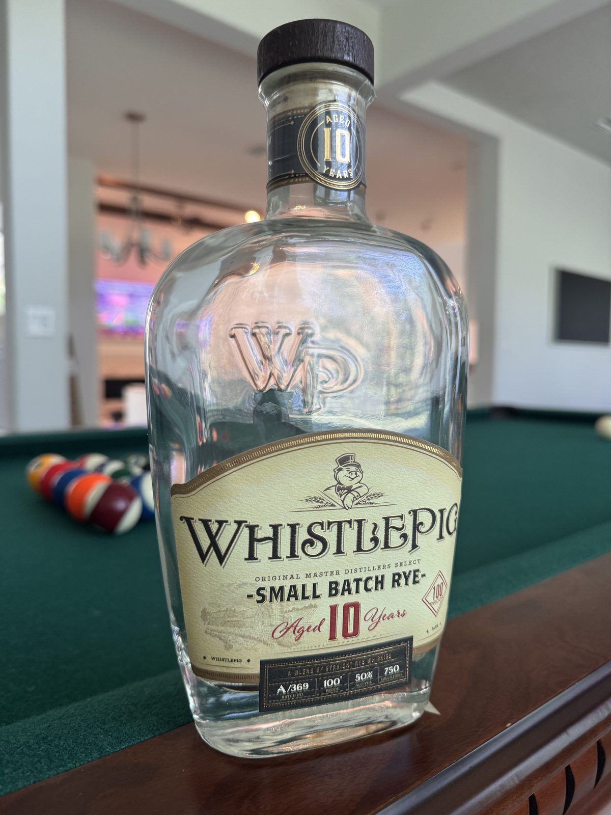 Empty WhistlePig 10 Year Small Batch Rye bottle (100 proof) on a pool table — first-hand RyeCentral review photo